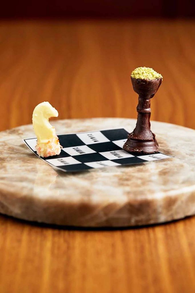 Xeque uma que apresenta dois chocolates em formato de peças do jogo, servidos em um mini tabuleiro
