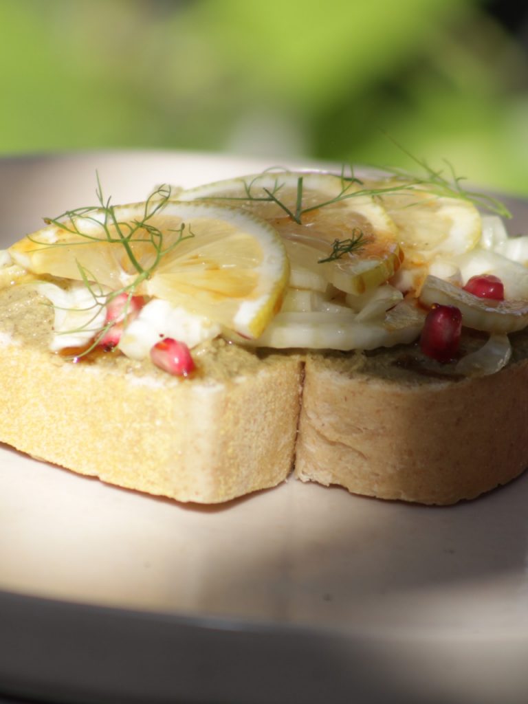 Toast de babaganoush, funcho, limão siciliano, romã e melado