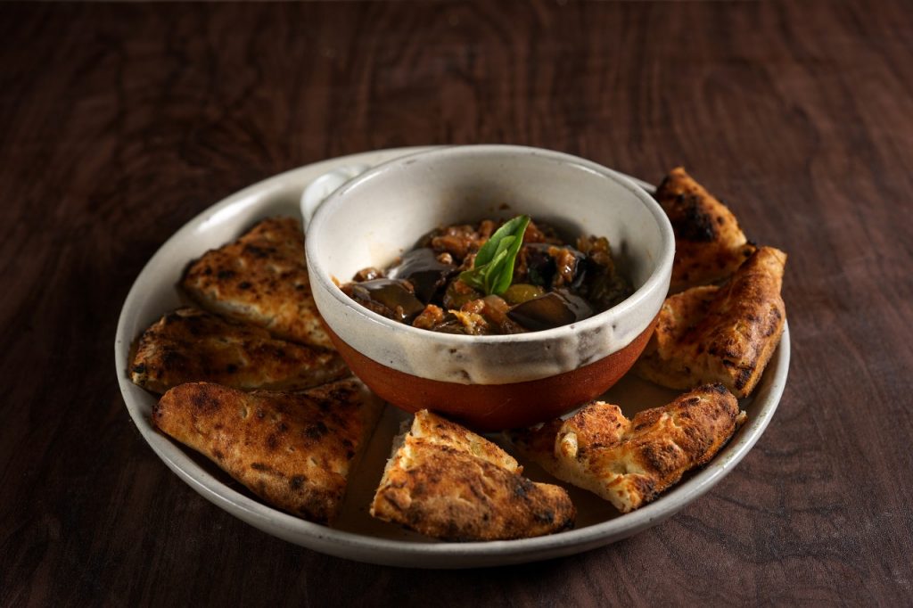 Pão da casa acompanhado de caponata - Vinny’s Pizzeria. Foto: Divulgação