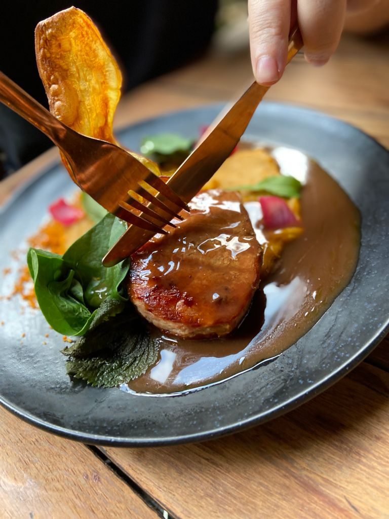 Lombo de porco duroc ao molho demi glace com purê defumado de abóbora, picles de cebola roxa e pancs