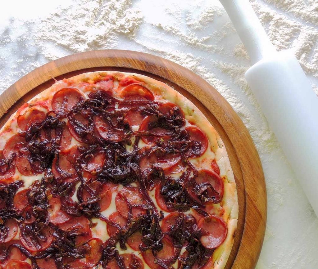 Calabresa Caramelizada com molho de tomate, muçarela, linguiça calabresa fatiada, cebola caramelizada, azeitonas pretas e orégano - Valentina Pizzaria. Foto: Divulgação