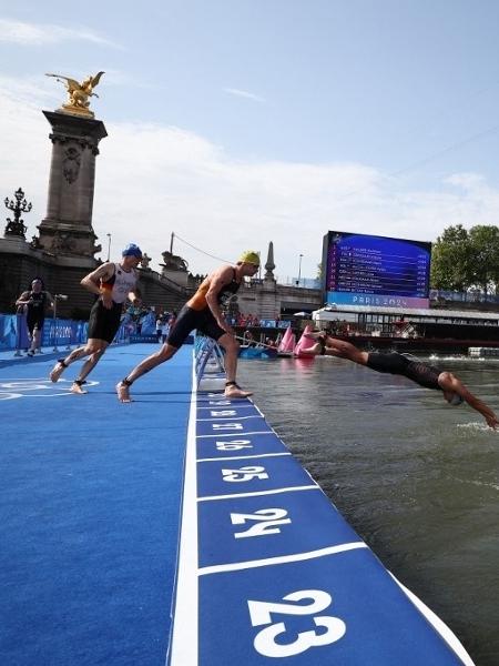 atletas competem na etapa de natacao no rio sena durante o triatlo individual masculino nos jogos olimpicos de paris 2024 em 31 de julho de 2024 1722427738873 v2 450x600