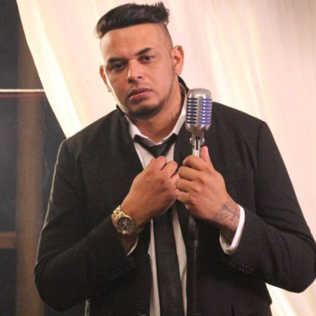 cantor cacau jr de terno e microfone de lapela