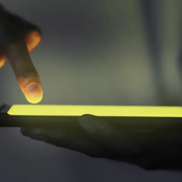 mao tocando a tela iluminada do smartphone