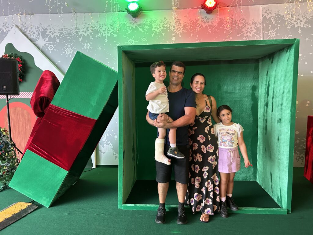 Gilberto Neto no colo de Gilberto Rodrigues, Edilane Souza Oliveira e a filha Gabriela Rodrigues no Natal Flor do Cerrado. Crédito: Amanda Karolyne