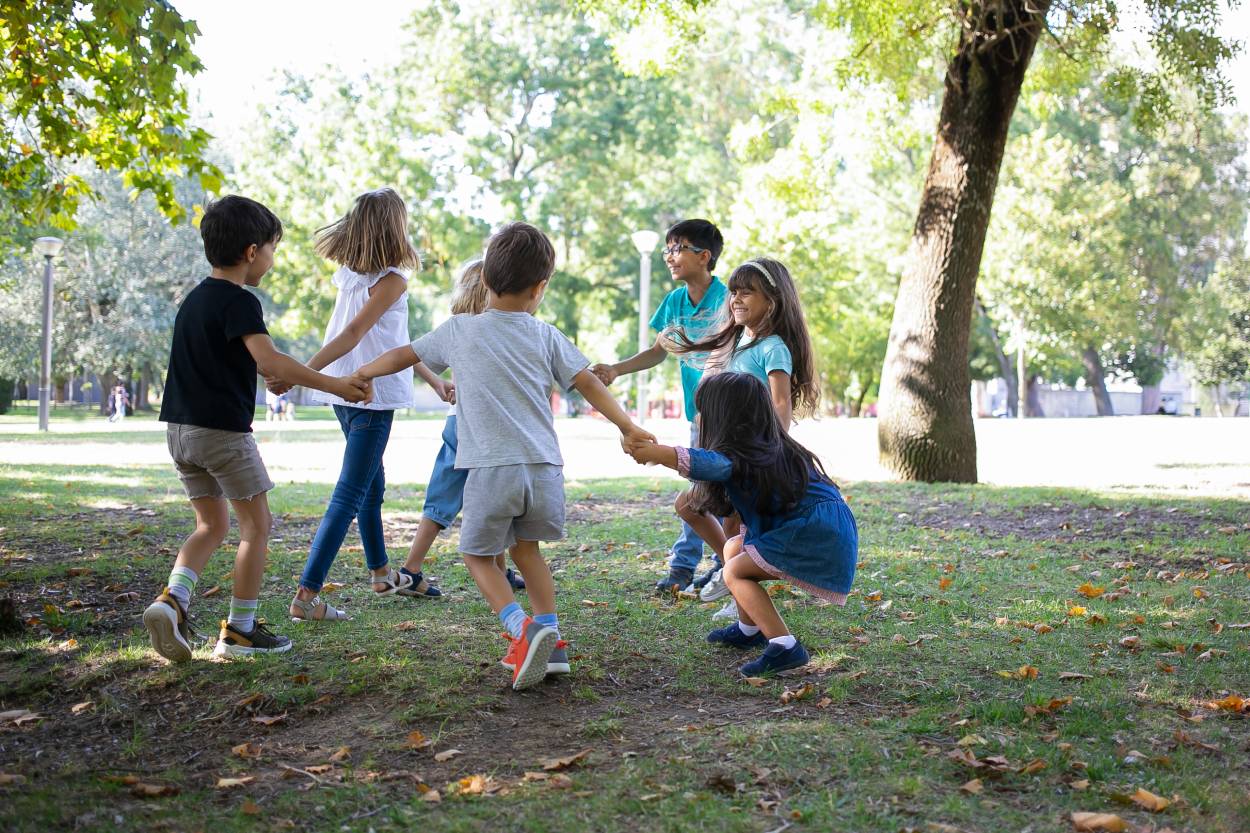 happy children playing together outdoors dancing around grass enjoying outdoor activities having fun park kids party friendship concept (1) (1)