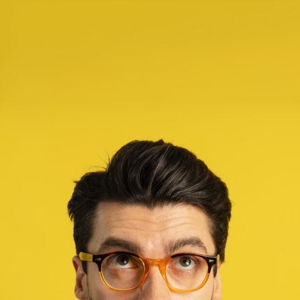 vista frontal de um homem com oculos olhando para cima com espaco de copia