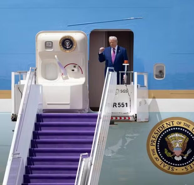 111024377 us president donald trump gestures as he exits his plane upon arriving at the airport in r