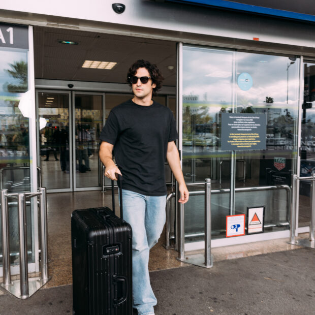 Ator brasileiro chega com look elegante e bagagem de luxo, reafirmando status de estrela internacional e queridinho das grandes maisons