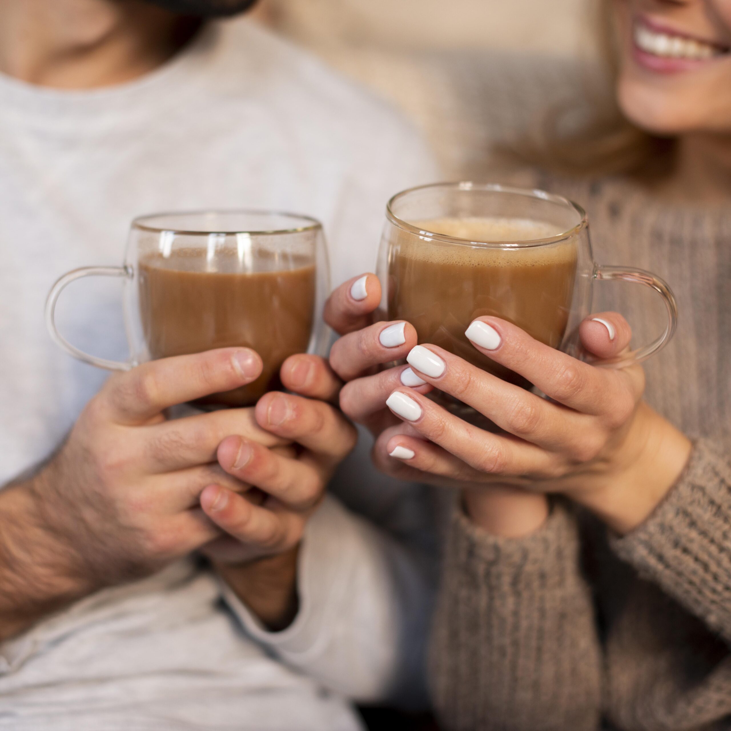 casal em close segurando bebidas