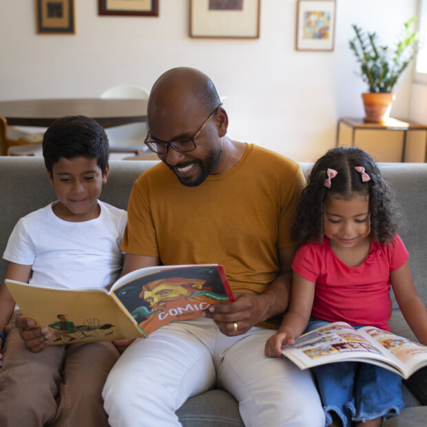 homem de tiro medio e criancas lendo quadrinhos em casa