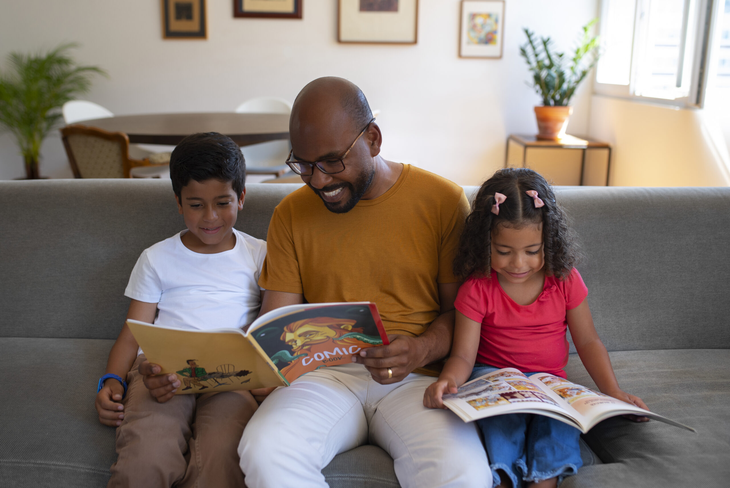 homem de tiro medio e criancas lendo quadrinhos em casa