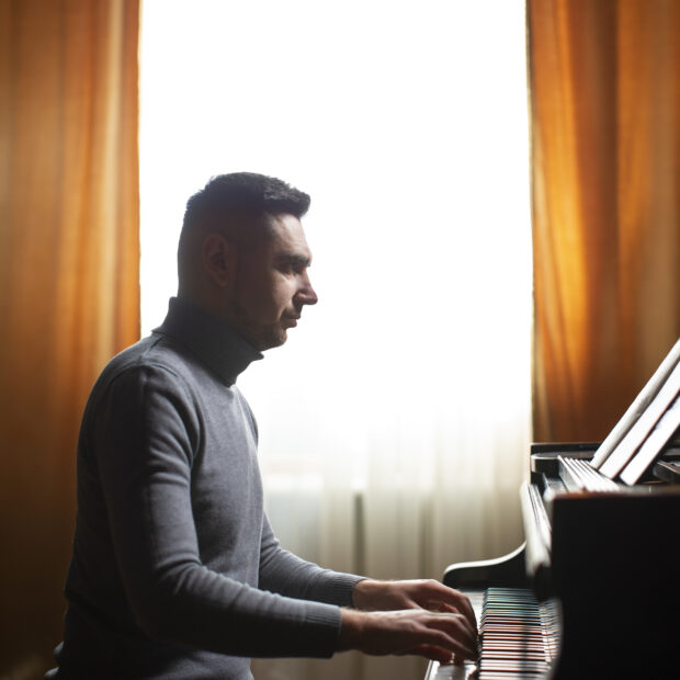 homem de vista lateral tocando piano