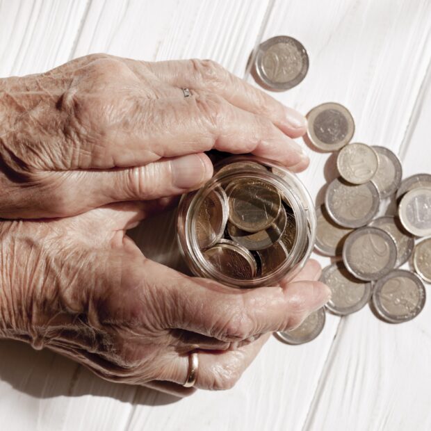 hands holding jar filled with coins