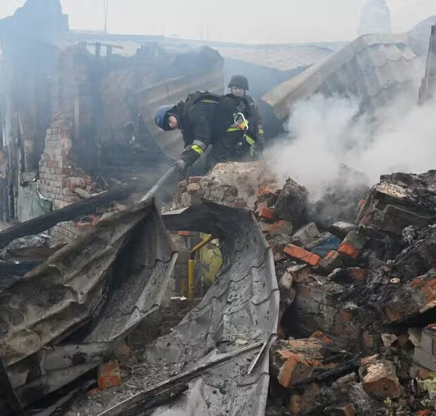Equipes de resgate trabalham para apagar incêndio em residência após ataque de drone em Kharkiv, Ucrânia — Foto: SERGEY BOBOK / AFP