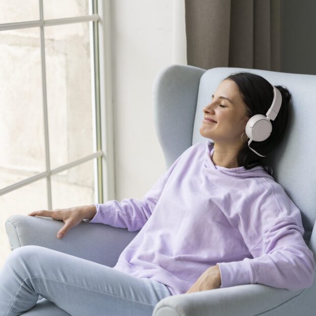 mulher jovem ouvindo musica em casa