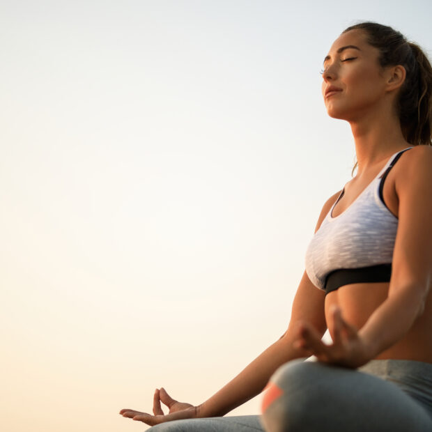 below view of woman meditating against the sky.