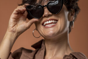 mulher sorridente com oculos escuros