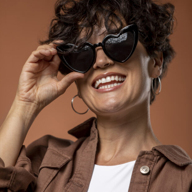 mulher sorridente com oculos escuros
