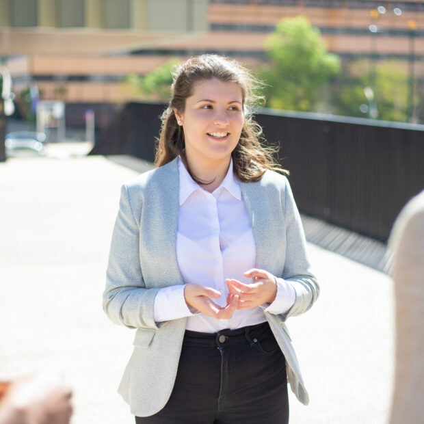 smiling caucasian woman talking to friends on street