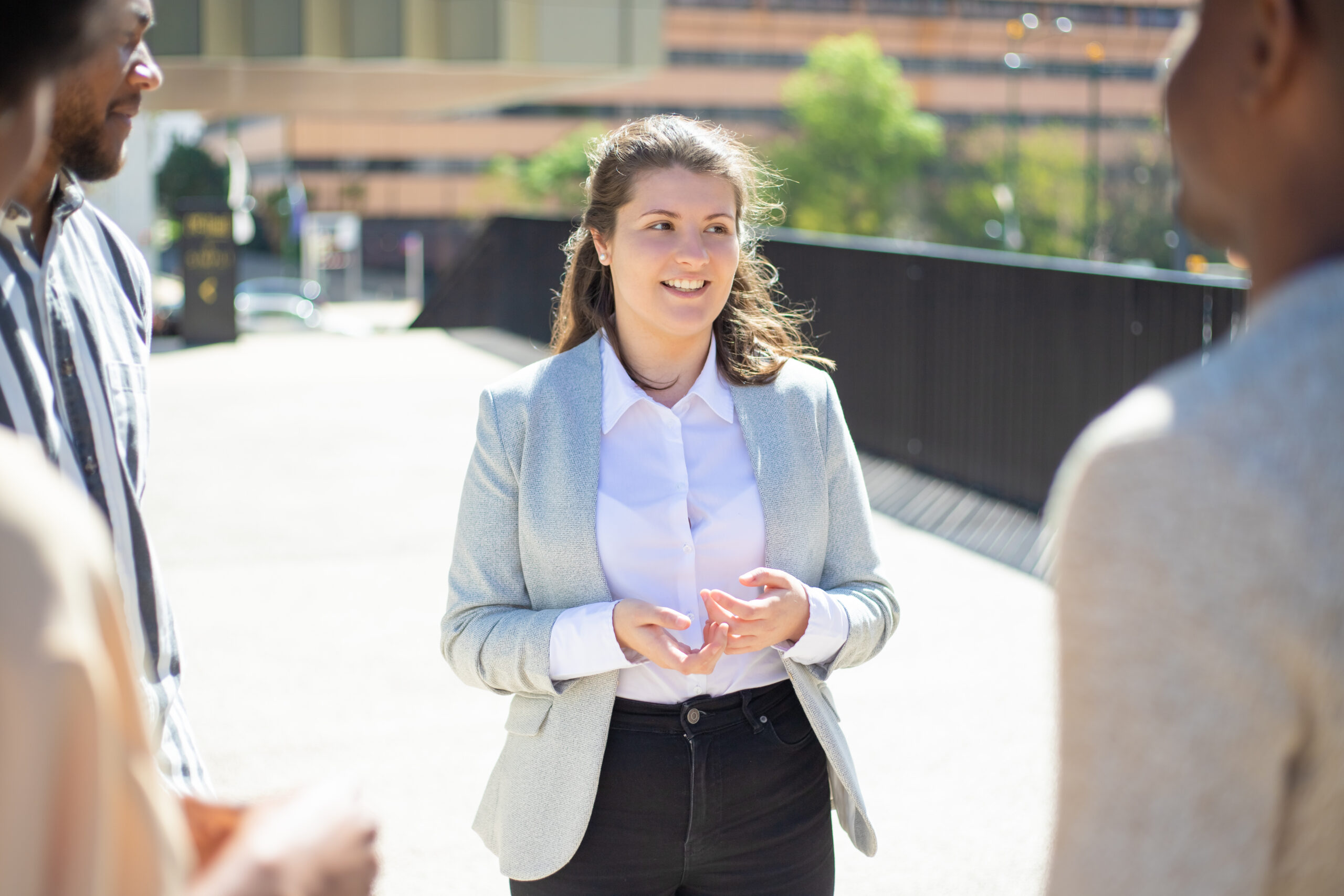 smiling caucasian woman talking to friends on street