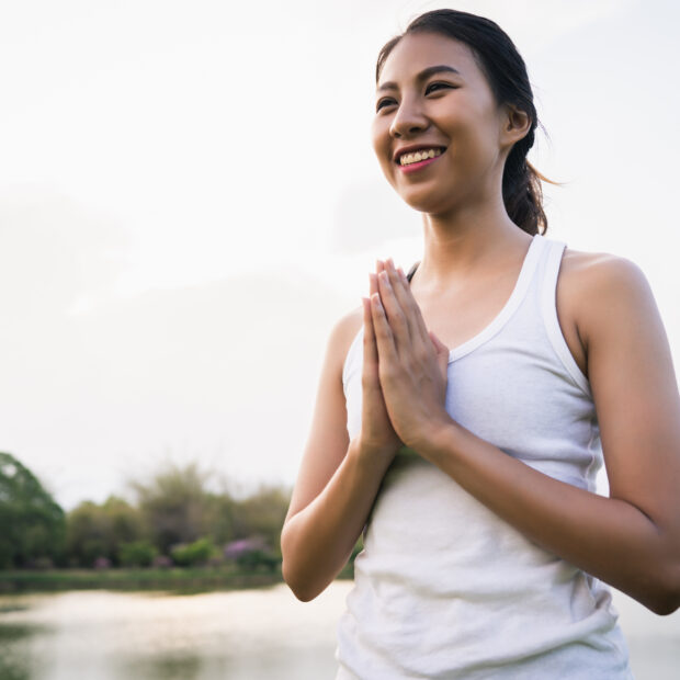 young asian woman yoga outdoors keep calm and meditates while pr