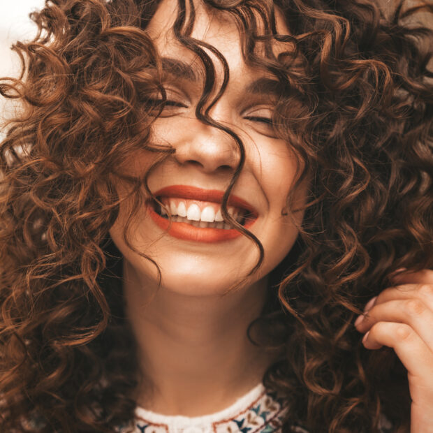 retrato da bela modelo sorridente com penteado afro cachos