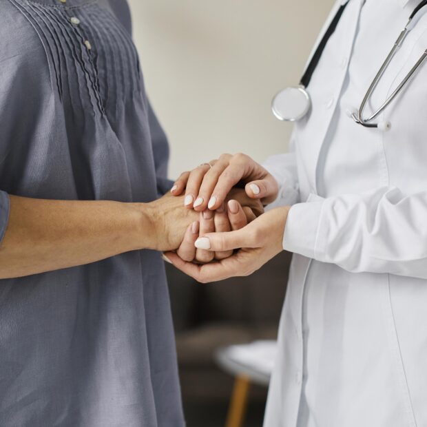 medica centro de recuperacao covid segurando as maos de uma paciente mais velha
