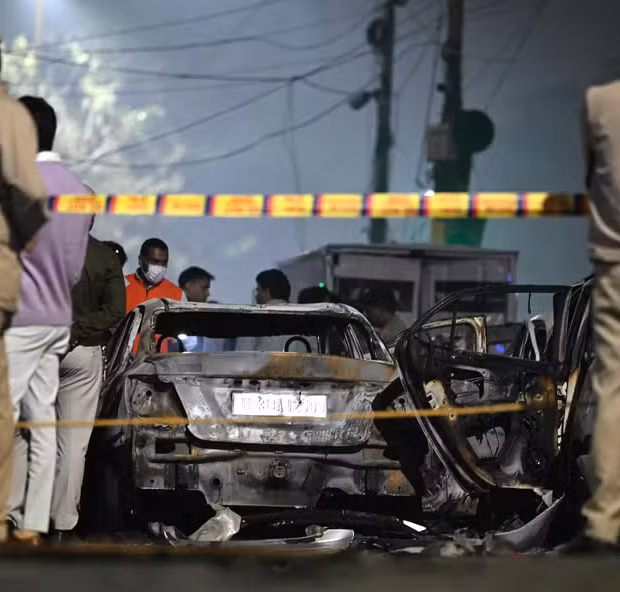 112975157 security personnel stand beside charred vehicles at the blast site after an explosion near
