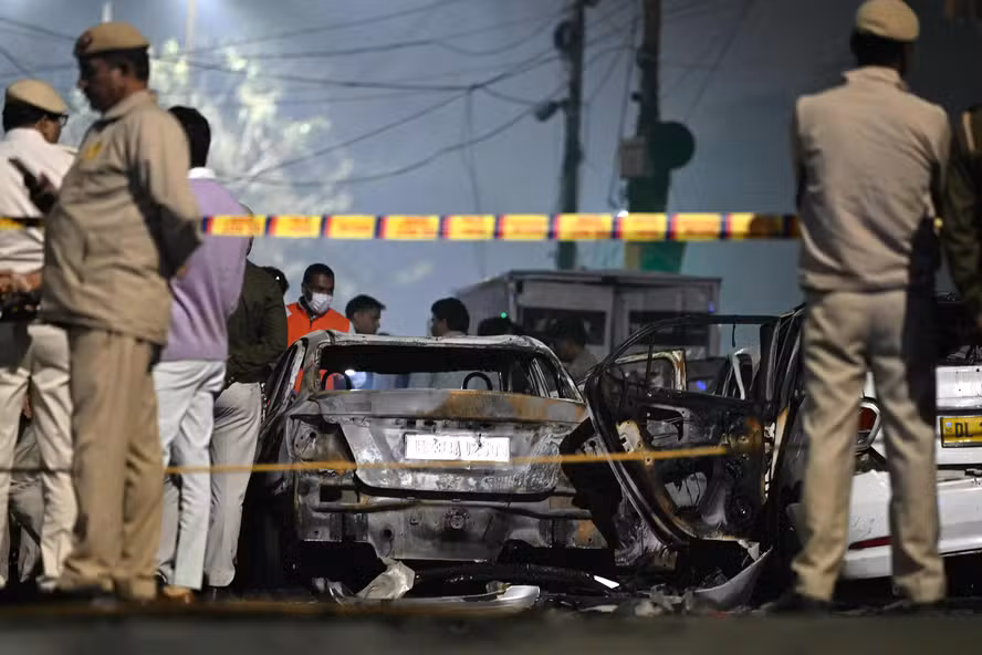 112975157 security personnel stand beside charred vehicles at the blast site after an explosion near