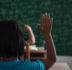 kid raising his hand in classroom
