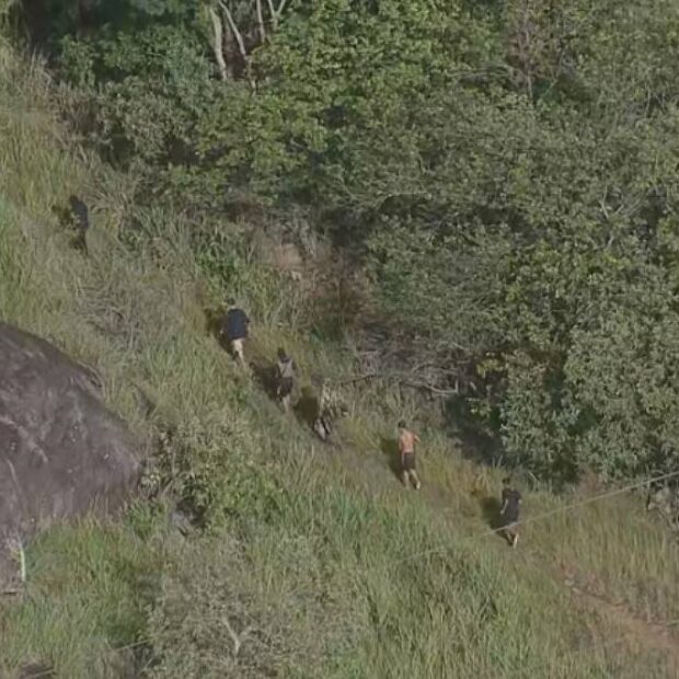 homens armados fogem pela mata durante operação no rj