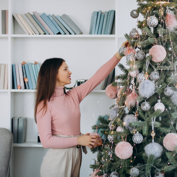 young woman decorating christmas tree