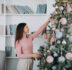 young woman decorating christmas tree