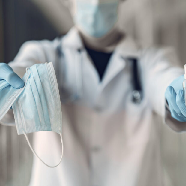 doctor hold the antiseptic and masks in his hand