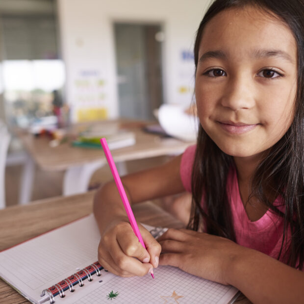 asian girl creating in her notebook