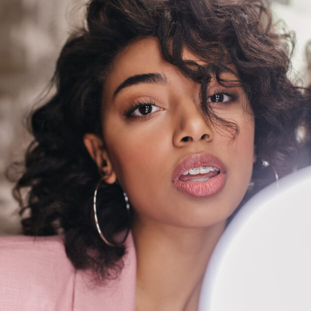 portrait of sensual brunette girl in pink jacket. studio shot of adorable young woman on blur background