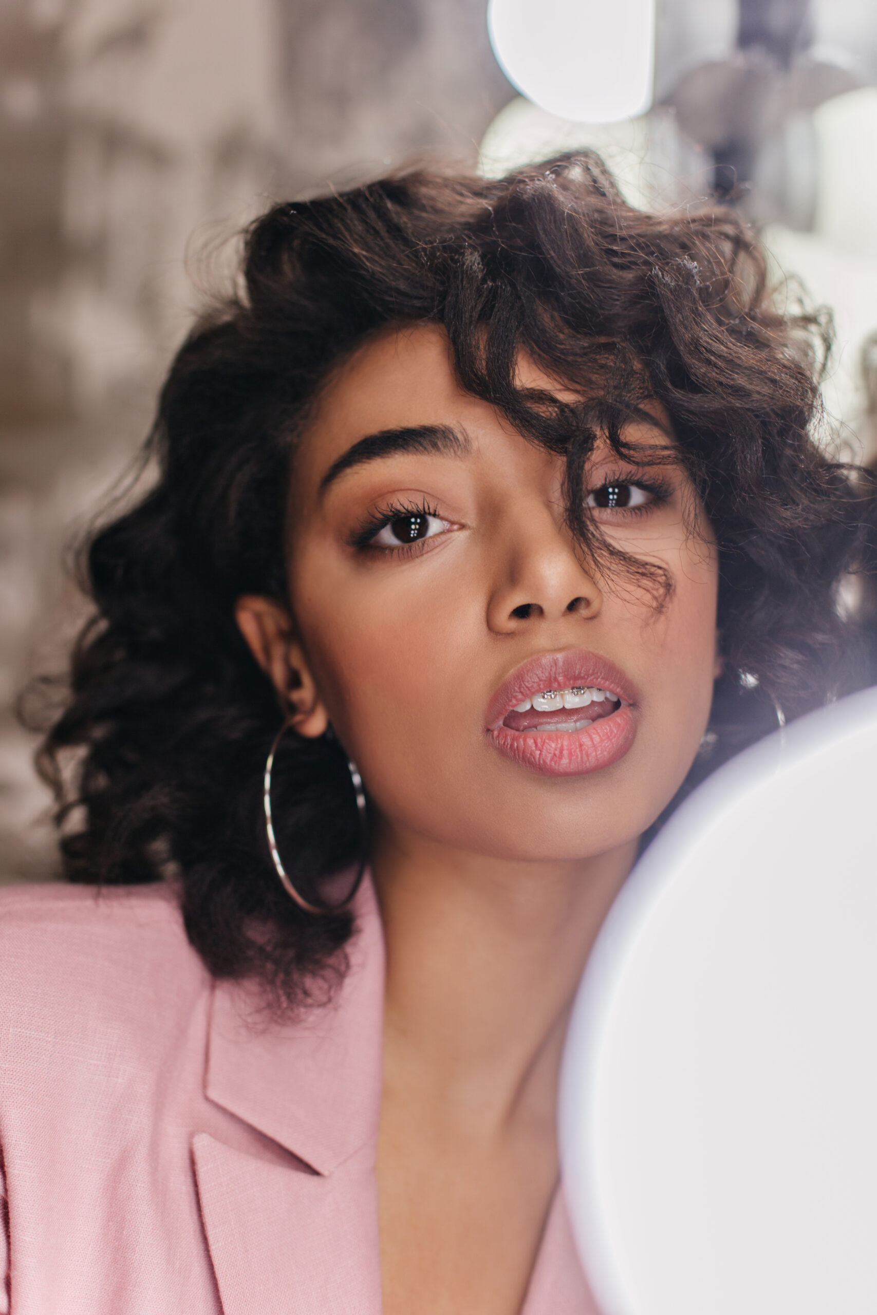 portrait of sensual brunette girl in pink jacket. studio shot of adorable young woman on blur background