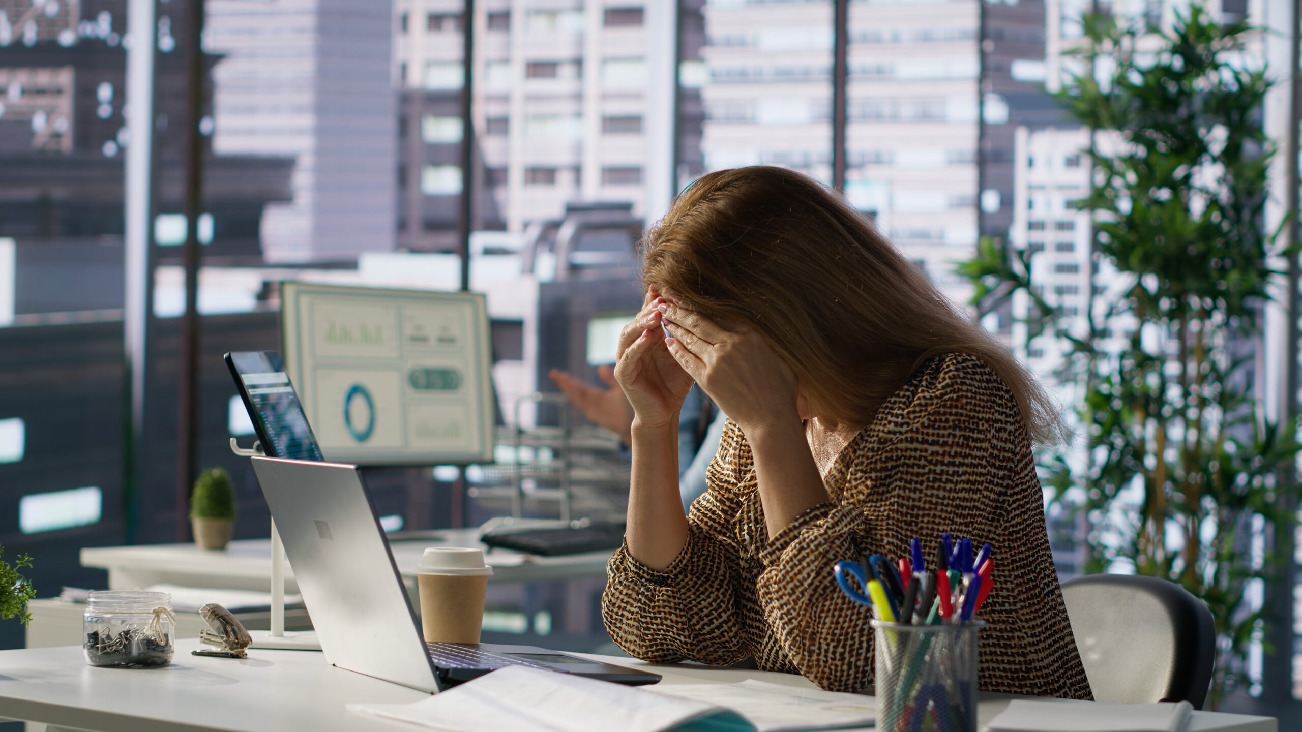 successful woman battles a headache while managing her financial projects