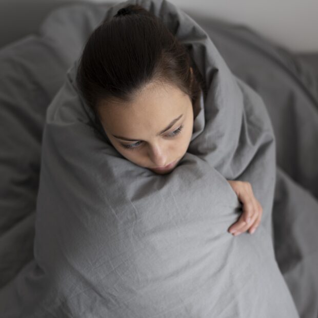 medium shot woman covering with blanket