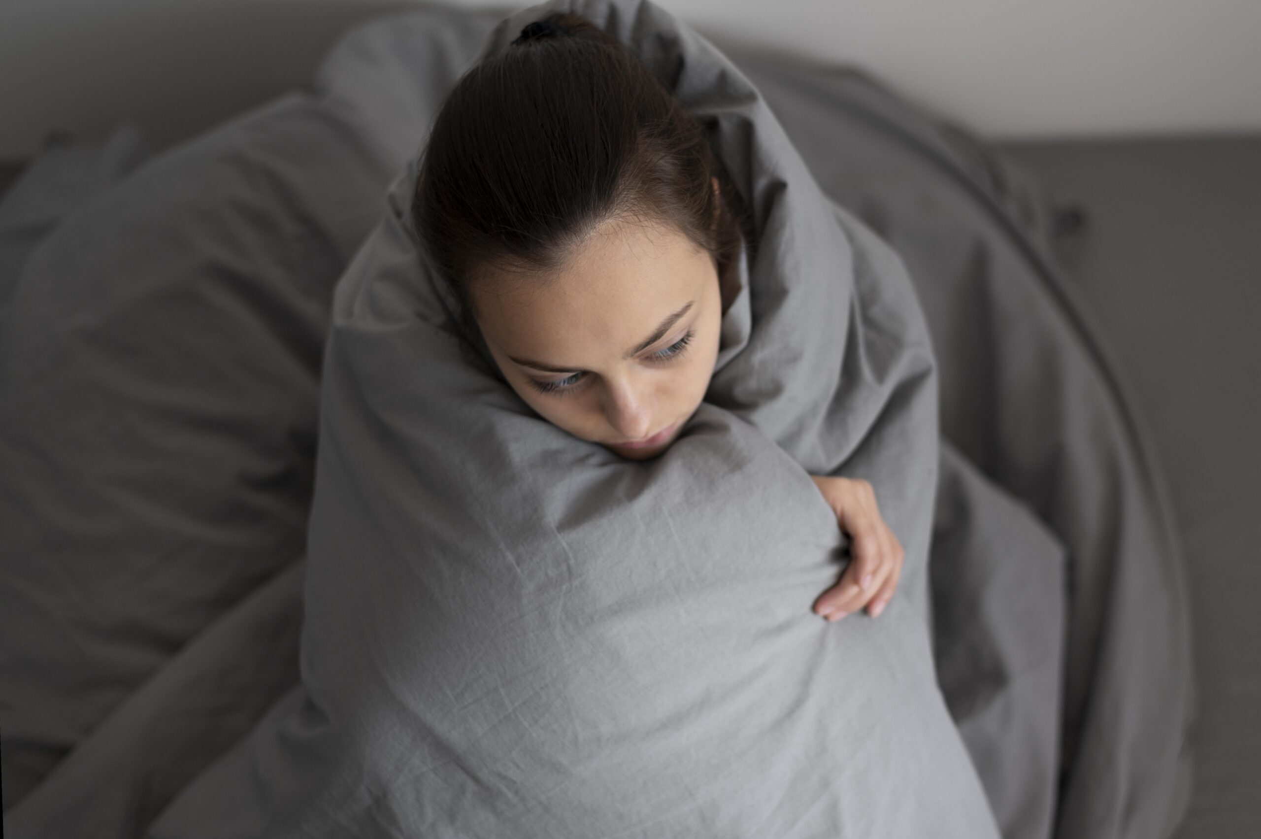 medium shot woman covering with blanket