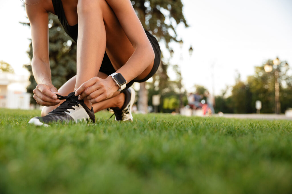 close up of fitness girl tying her shoelaces