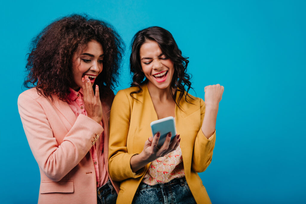 excited latin woman making selfie with friend. trendy african girl posing in studio