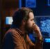 programmer using computer to update ai neural networks, drinking coffee