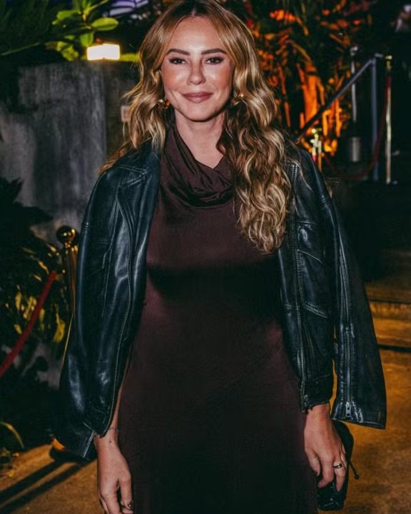 Atriz combinou a peça longa com jaqueta de couro preta no estilo biker
