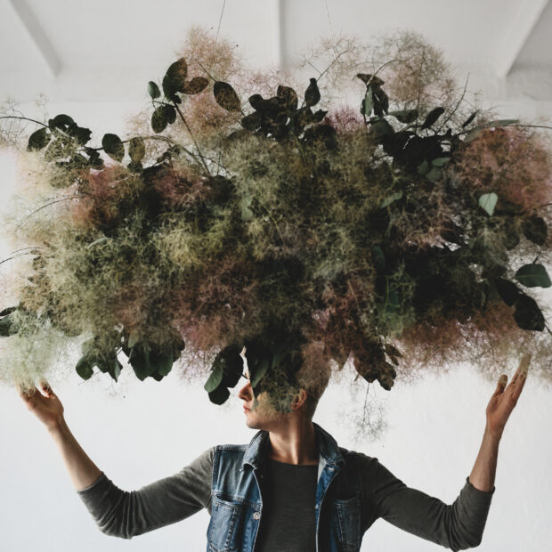large decorative bouquet made of green leaves and moss hangs ove