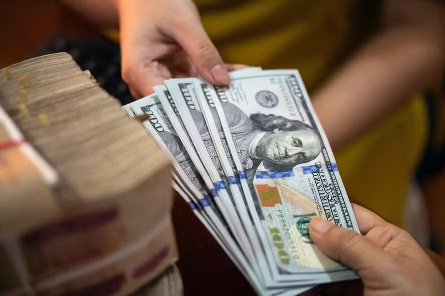 107113510 this photo illustration shows us dollar notes r next to a stack of myanmar kyat notes in y