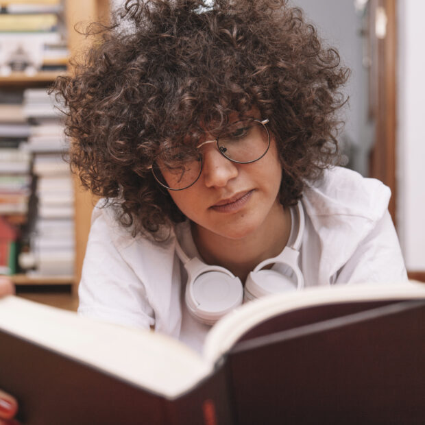 teenager glasses reading book floor