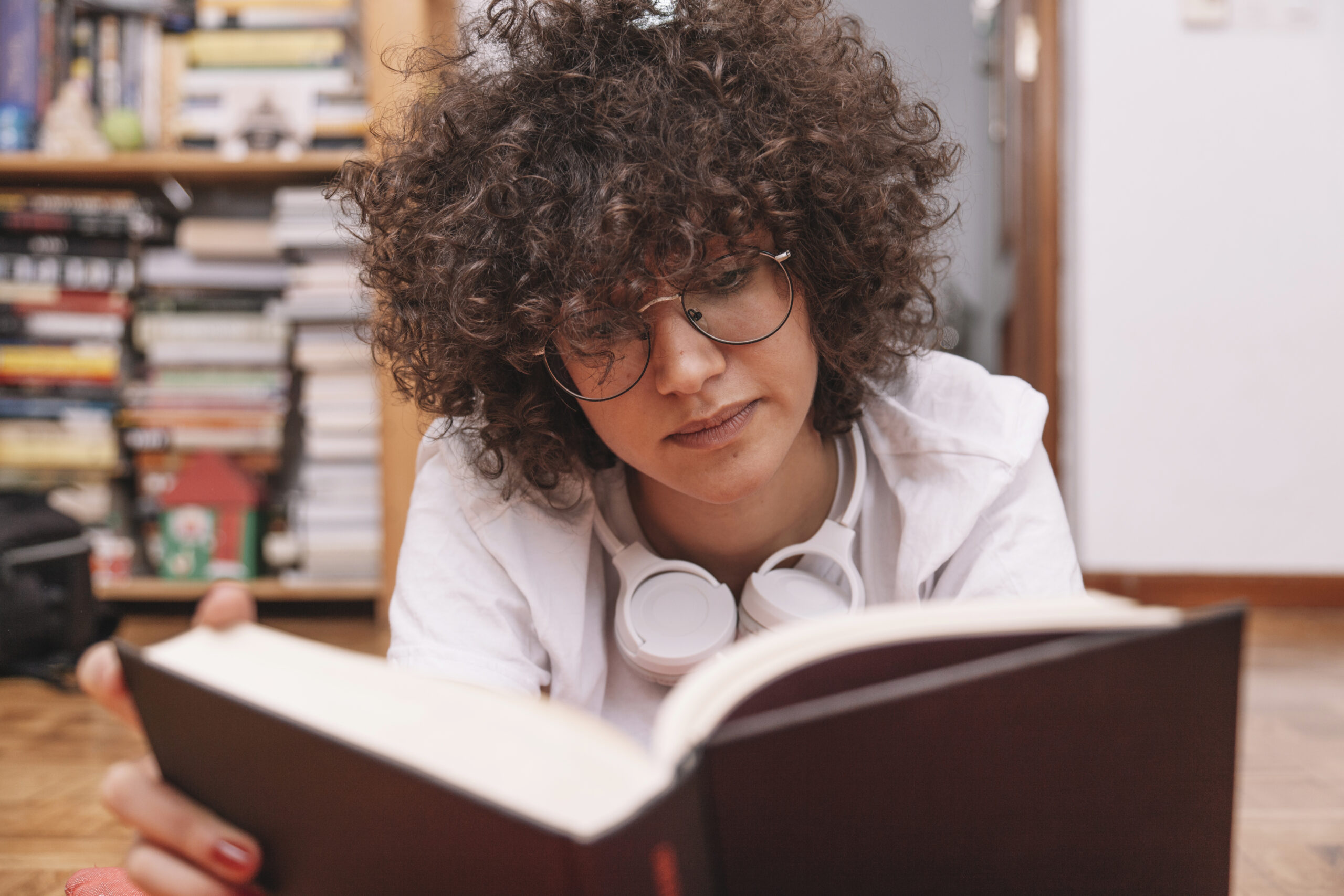 teenager glasses reading book floor