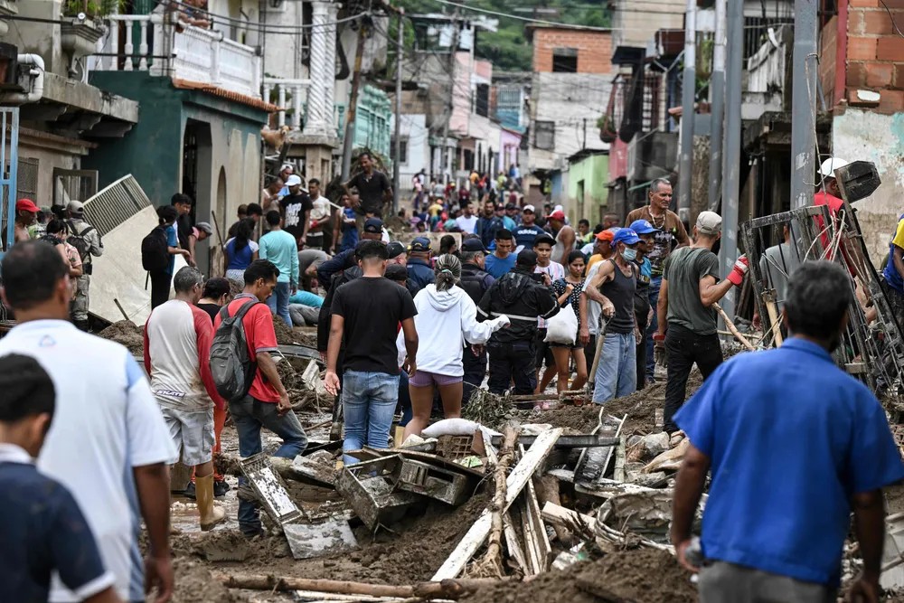 100783386 topshot residents walk among the rubble of destroyed houses washed away by a landslide d